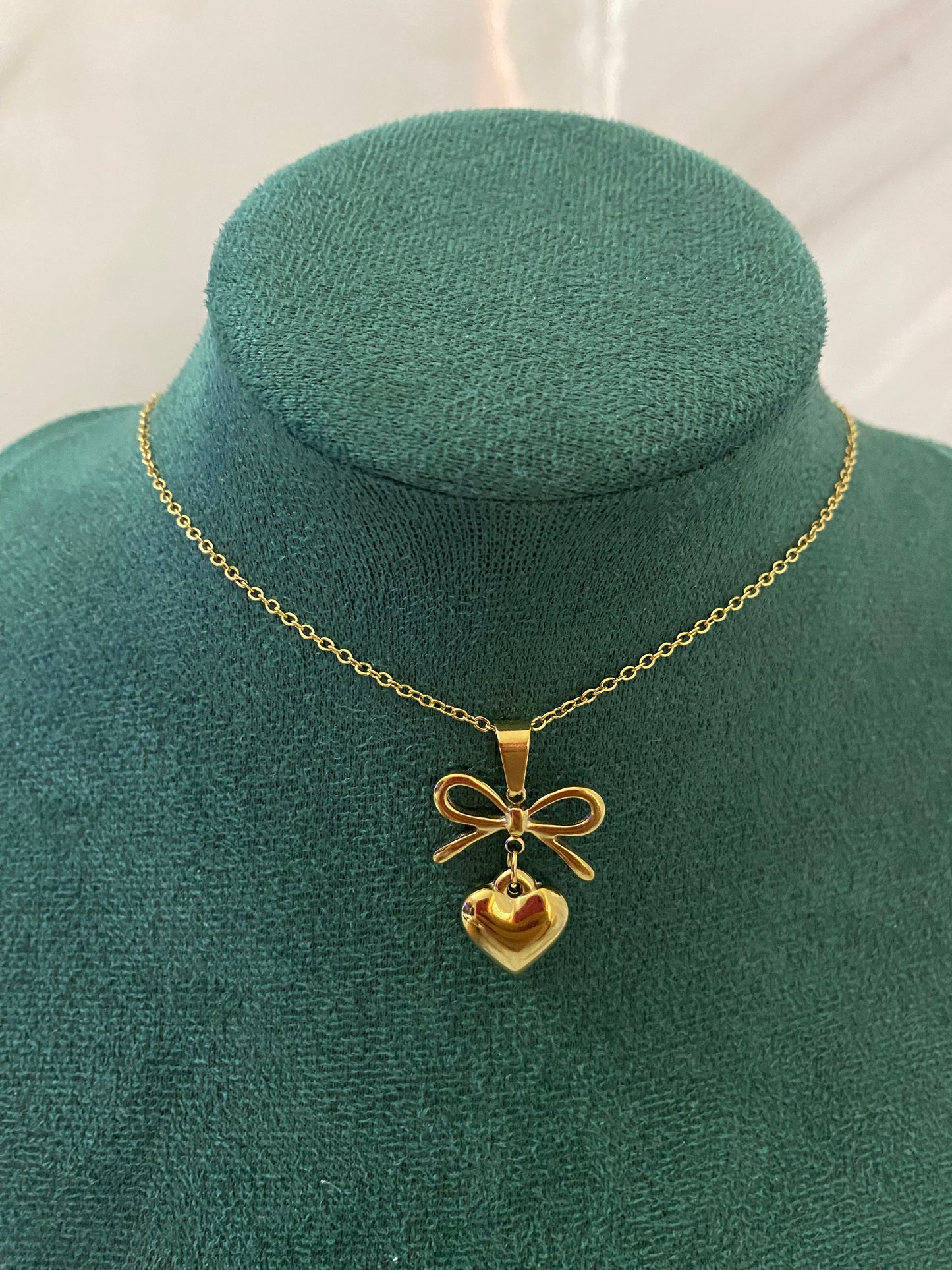 Gold Heart Bow Necklace featuring a delicate heart pendant with an elegant bow detail, crafted from premium stainless steel. Waterproof, tarnish-free jewelry for women, ideal for everyday wear, gifting, parties, weddings, anniversaries, and special occasions.
