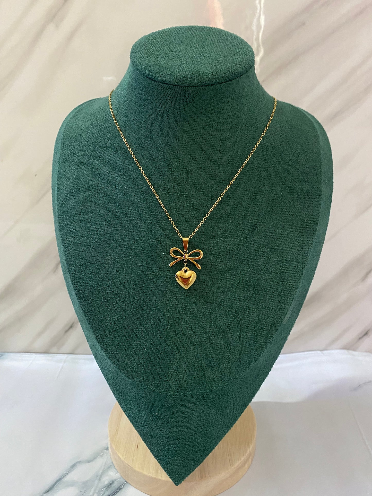 Gold Heart Bow Necklace featuring a delicate heart pendant with an elegant bow detail, crafted from premium stainless steel. Waterproof, tarnish-free jewelry for women, ideal for everyday wear, gifting, parties, weddings, anniversaries, and special occasions.
