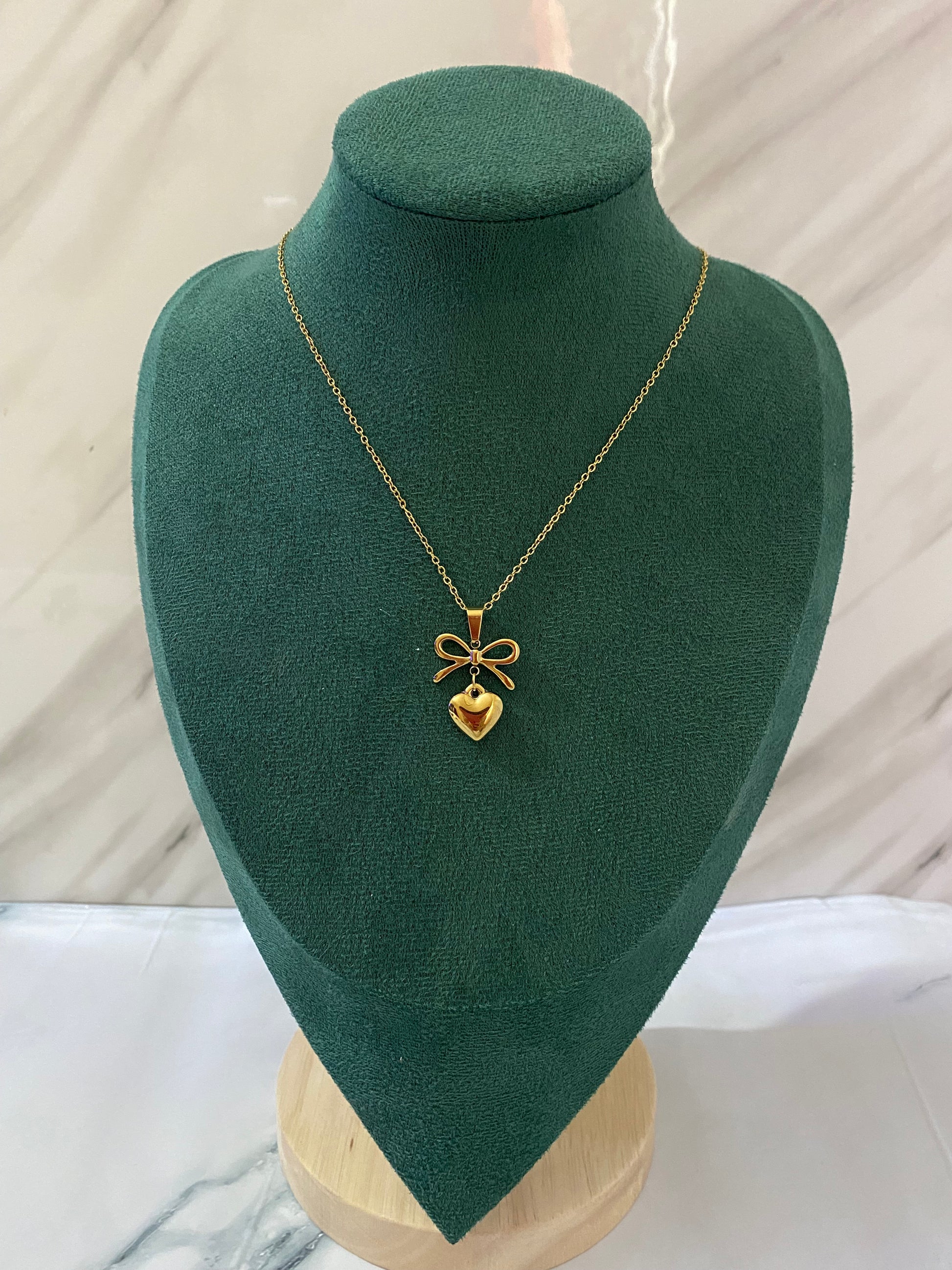 Gold Heart Bow Necklace featuring a delicate heart pendant with an elegant bow detail, crafted from premium stainless steel. Waterproof, tarnish-free jewelry for women, ideal for everyday wear, gifting, parties, weddings, anniversaries, and special occasions.
