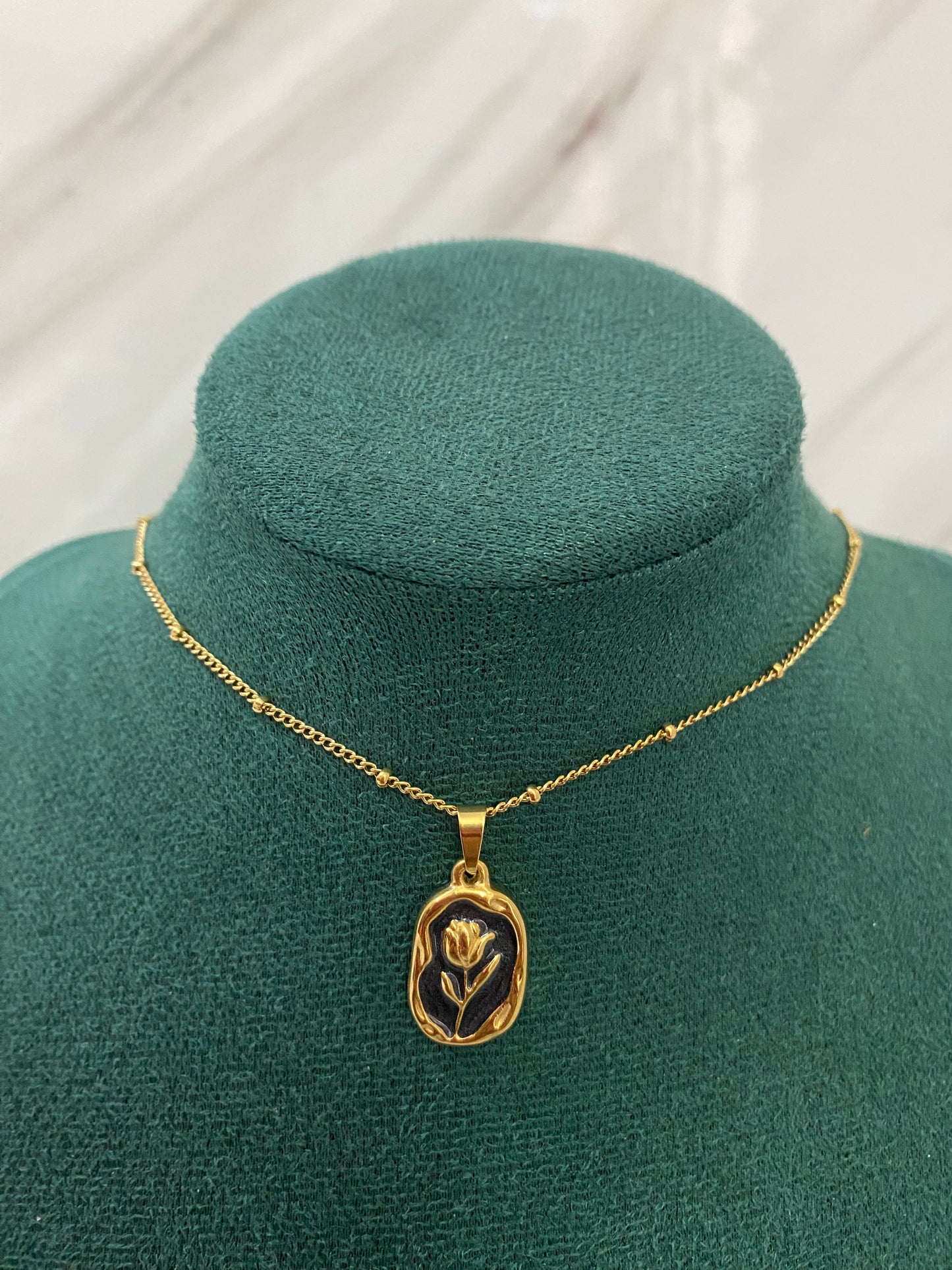 Gold Tulip Black Stone Necklace featuring an elegant tulip-inspired pendant with a sophisticated black stone detail. Crafted from premium stainless steel, this waterproof and tarnish-free necklace is perfect for women’s everyday wear, weddings, parties, gifting, and special occasions.
